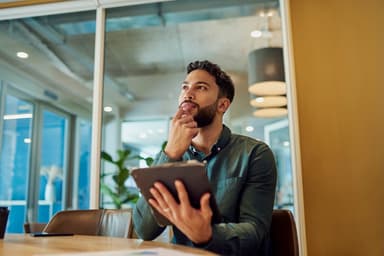 Man researching HELOC options on a tablet.