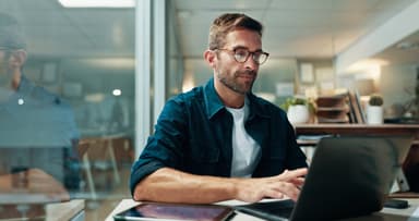 Man looks for a new job on a laptop.