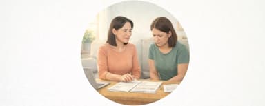 Two women reviewing bankruptcy paperwork together at a kitchen table