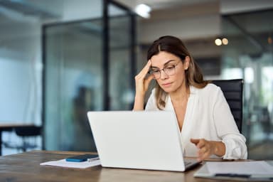 Woman using a laptop to research personal loan lenders.