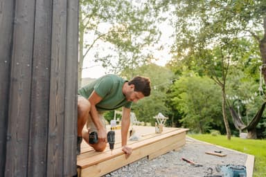Man builds deck at his house.