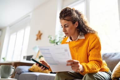 Woman reads financial paperwork.