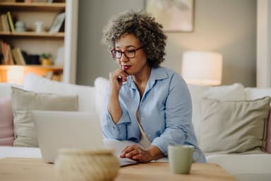 Woman checking out her debt consolidation and settlement options on a laptop.