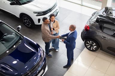 Couple talks to car salesperson at a dealership