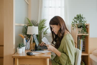 Woman pays bills on her laptop.