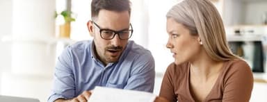 Young couple reviewing letter from debt collector