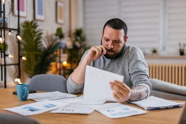 Young man reviews financial statements.